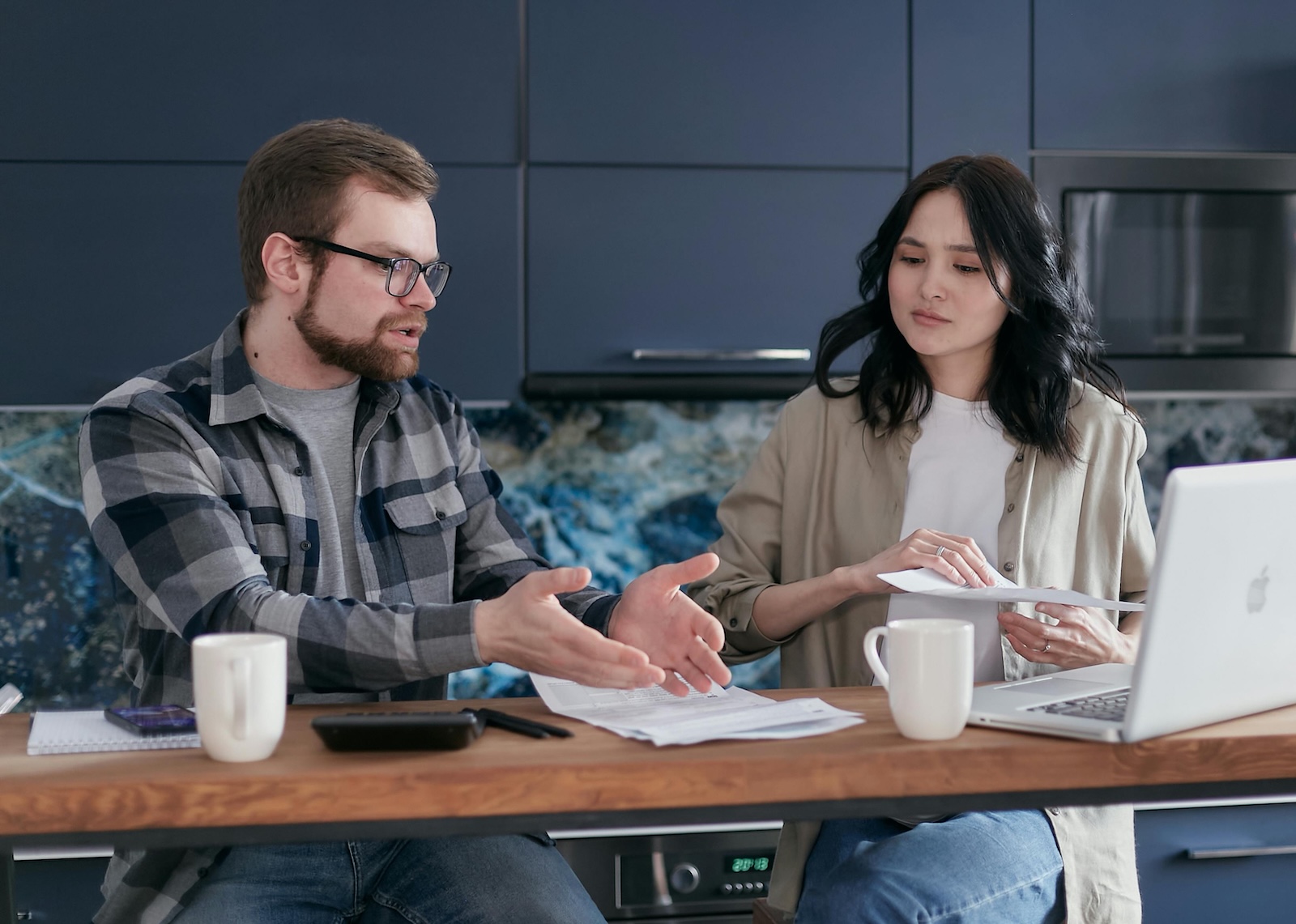 Couple paying bills at the table with computers