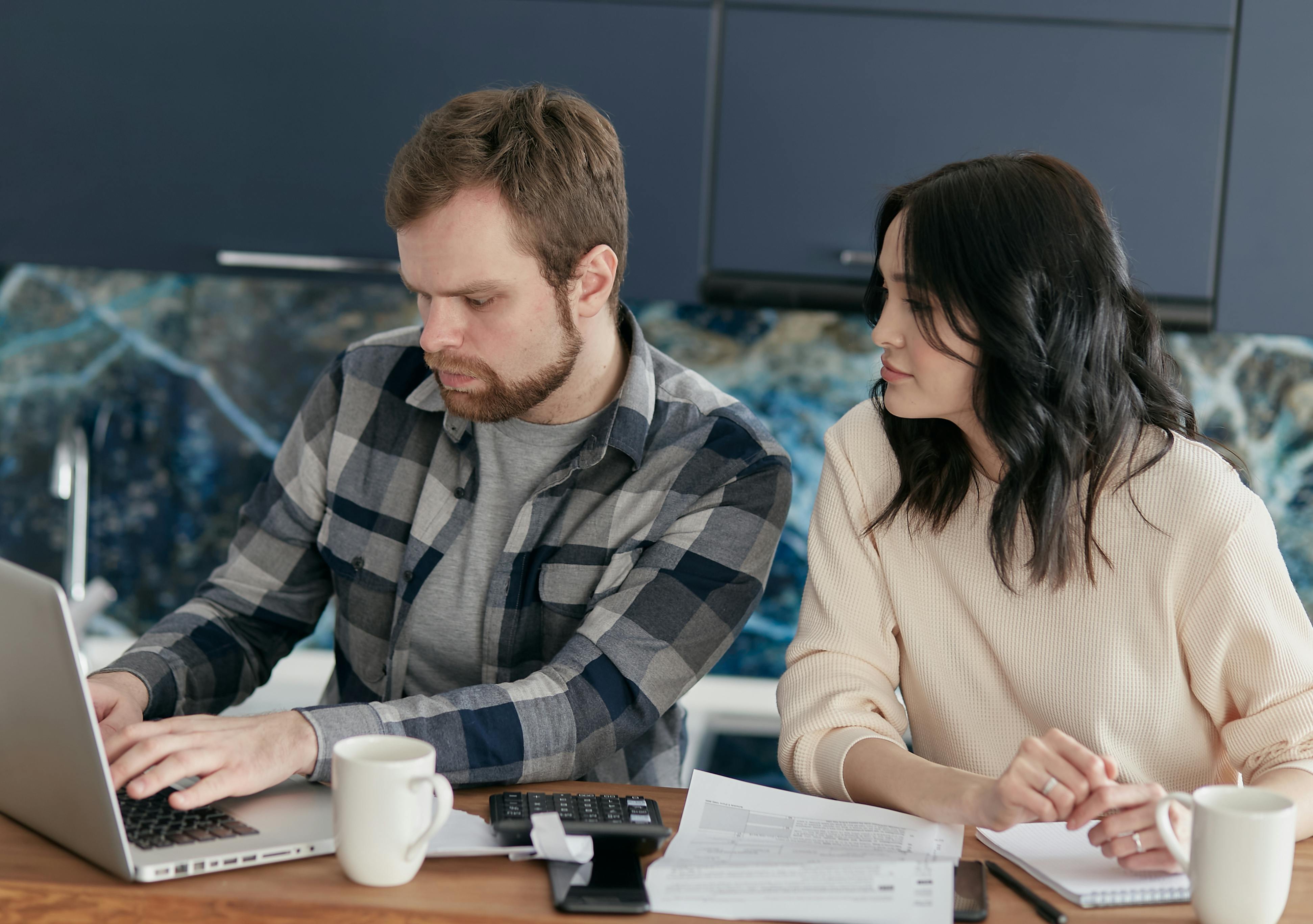 Couple planning finances together with laptop and paperwork